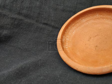 Gros plan d'argile traditionnelle à la main vide ou bol de couleur brun sable, couvercle de pot isolé sur un fond noir.