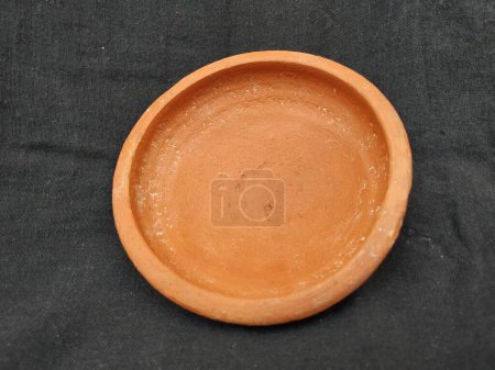 Closeup of Empty Handmade Traditional Clay or Sand Brown Color Bowl, Pot Lid isolated on a Black Background.