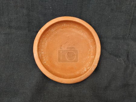 Closeup of Empty Handmade Traditional Clay or Sand Brown Color Bowl, Pot Lid isolated on a Black Background.