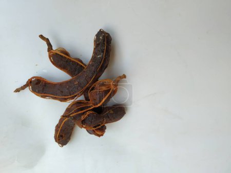 Primer plano de la fruta del tamarindo tropical. Pelado, sin cáscara, con semillas visibles y pulpa interior. Aislado sobre fondo blanco