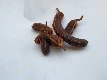 Closeup of Tropical tamarind fruit. Peeled, without shell, with visible seeds and inner pulp. Isolated on white background