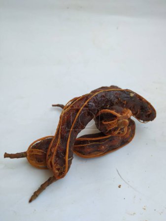 Primer plano de la fruta del tamarindo tropical. Pelado, sin cáscara, con semillas visibles y pulpa interior. Aislado sobre fondo blanco