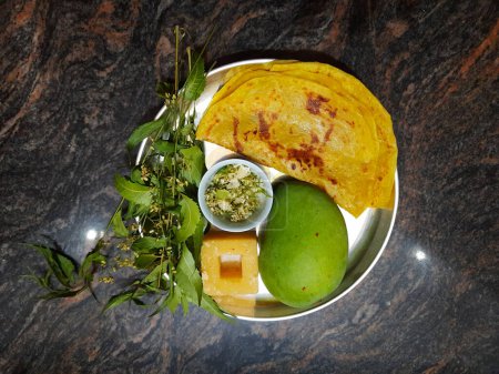 Closeup of beautiful and delicious Ugadi special food like Mango, Jaggery, Neem and Sweet Poli or Obbattu.