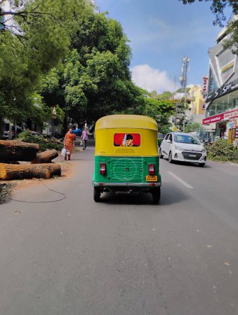 Téléchargez les photos : Bangalore, Karnataka, Inde-5 juin 2024 : Vue arrière rapprochée de l'arrêt Rickshaw automatique jaune et vert à Signal. Célèbre acteur Kannada défiant Star Darshan Film peinture sur le dos - en image libre de droit