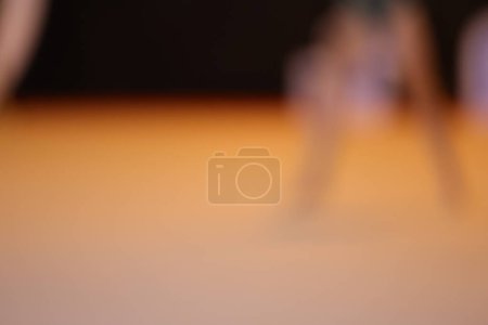 Foto de Fondo naranja oscuro abstracto con manchas blancas. La silueta de los gimnastas es visible - Imagen libre de derechos
