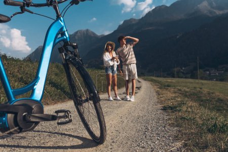 Photo for Two friends or couple are cycling along the road. Sport and active life sunset time concept. Couple learning to ride a bike, having fun together, traveling in the mountains near the city - Royalty Free Image