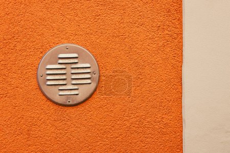 Photo for Round metal grille of the recuperator on the orange wall - Royalty Free Image
