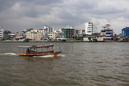 Foto de Los turistas montan un bote de cola larga a lo largo del río Chao Phraya en un recorrido turístico - Imagen libre de derechos