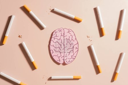 Fumar daña la salud cerebral. Tabaco o cigarrillos con símbolo de órgano cerebral humano sobre fondo marrón. Fumar aumenta el riesgo de padecer afecciones cerebrales, como demencia y accidente cerebrovascular. Día mundial sin tabaco.