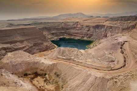Téléchargez les photos : Cratère massif dans une ancienne carrière de cuivre pleine d'eau dans le lac caché dans le parc de Timna, au sud d'Israël - en image libre de droit