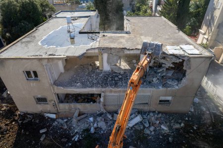 Dismantling of a house. Excavator demolishing barracks for a new construction project. 