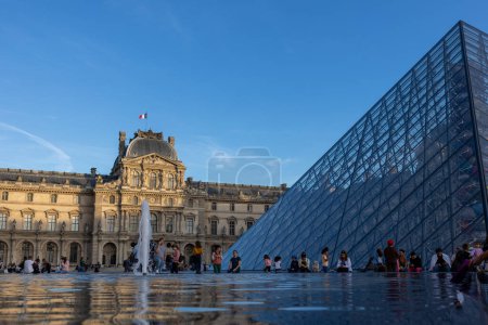 Photo for Louvre Museum, Pyramids, fountain. Tourists walk on the square of the Louver Museum. - Royalty Free Image
