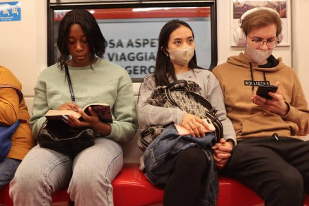 Téléchargez les photos : Des gens de différentes ethnies s'assoient les uns à côté des autres dans le métro. - en image libre de droit