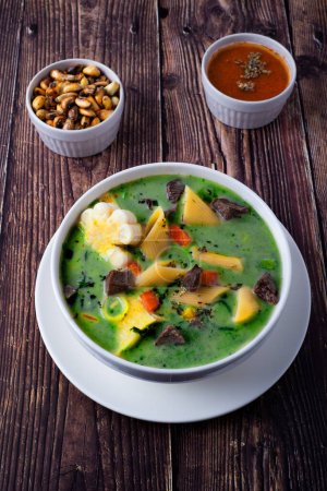 Foto de Un tazón de sopa peruana de menestrón. Con trozos de carne, fideos, zanahorias picadas, maíz y cilantro para darle el color verde. - Imagen libre de derechos