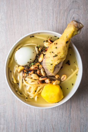 Foto de Vista aérea de un plato de sopa de pollo, con huevo duro, patata amarilla, cancha serrana, fideos y orégano. - Imagen libre de derechos