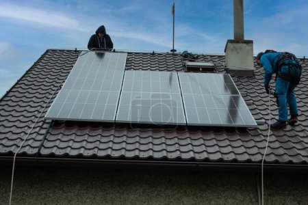 Foto de Installation of photovoltaic panels. Construction of the photovoltaic power plant of the family house. - Imagen libre de derechos