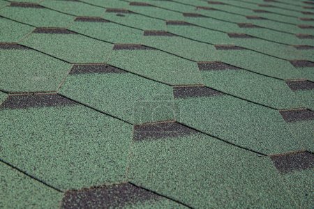 Photo for Roofing made of green soft bitumen tiles on a hipped roof of a house. Close up view of Asphalt Roofing green Tile Background. Green tiles on the roof of the house. Roof Shingles, Roofing Repair. - Royalty Free Image