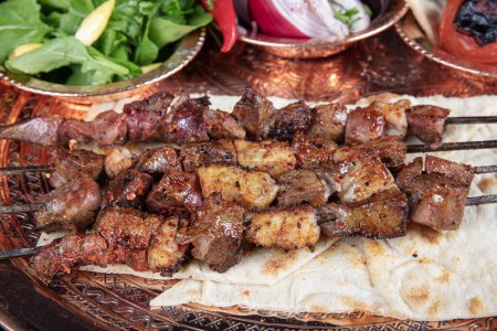 Photo for Liver kebab, one of Adana's special tastes. street flavors. Grilled beef liver on skewers, with teriyaki or soy sauce. Ciger kebab, table, liver on skewers. - Royalty Free Image