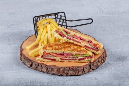 Photo for Turkish bazlama toast, flat baked bread toasted. Bazlama, Freshly baked appetizing Turkish tortillas. Flatbread toast with salami, kavurma, turkish sausage and cheddar on a table. - Royalty Free Image