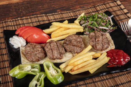 Téléchargez les photos : Boulette de viande turque kofte traditionnel. Boulettes de viande épicées Kebab ou Kebap. Boulettes de viande turques aux poivrons verts frais et aux cornichons. - en image libre de droit