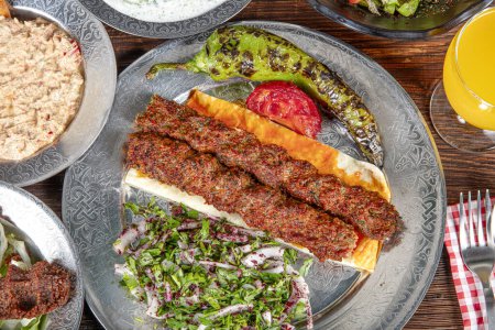 Adana turca a la parrilla, Urfa Kebab con verduras a la parrilla, cebolla y arroz en el plato. Adana durum.