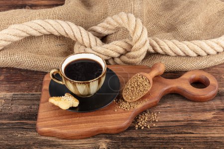 Instant granulated coffee. Coffee beans on or instant granulated coffee. Dry instant coffee in a black ceramic dish next to coffee beans isolated.