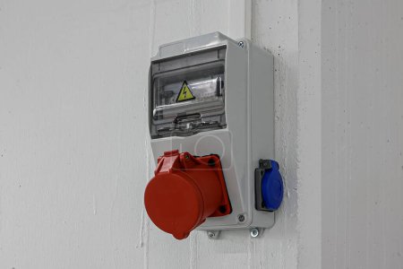 Photo for Outdoor Electrical Box with Single and Three Phase Current Electrical Appliances and Power Outlets. Three phase connectors. In a factory hall, red and blue, 220 volt and 380 volt sockets. - Royalty Free Image