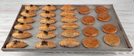 Pastries made from buckwheat flour on a baking tray. Sesame pastries made from chickpea, sorghum and buckwheat flour. Pastries made from various flours and seeds. Healthy and diet concept.