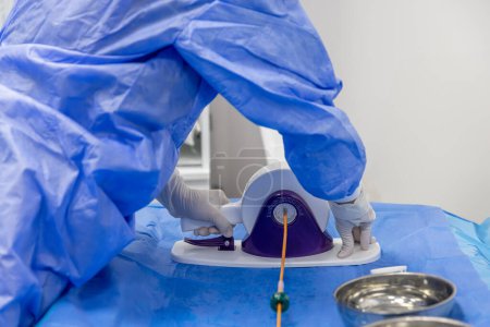 Outil de sertissage de valve cardiaque jetable. Dans la salle d'opération, le médecin prépare la valve cardiaque pour la transplantation au patient avec un outil de sertissage de valve cardiaque.
