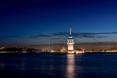 Photo for Iery sunset over Bosphorus with famous Maiden's Tower (Kiz Kulesi) also known as Leander's Tower, symbol of Istanbul, Turkey. Scenic travel background for wallpaper or guide book - Royalty Free Image