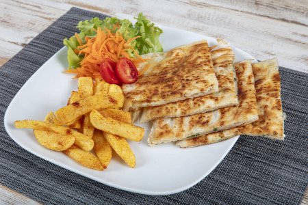 Freshly baked appetizing Turkish tortilla, cheese flatbread. Freshly baked Turkish Flatbread flatbread with greens and cheese.