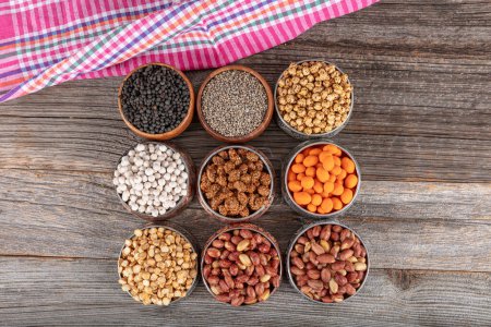 Assortment of nuts and seed on rustic table. Mixed snacks in a copper bowl. Background of various nuts (Chickpeas, chickpeas, peanuts, hazelnut). Vegetarian meal. Healthy eating concept.