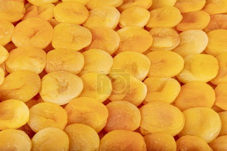 Gelbe getrocknete Aprikosen symmetrisch angeordnet. Getrocknete Marillenfrüchte. Leckere getrocknete Aprikosen als Hintergrund, Draufsicht. Gesunde Snacks.