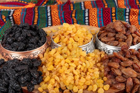 Collection of raisins that offers a vibrant and nutritious array. Three different types of raisins are arranged in rows. Texture of raisin grains of different colors.