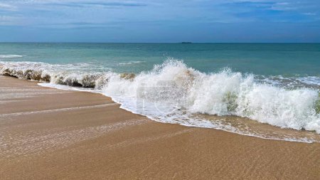 Téléchargez les photos : Vagues sauvages et mousse en mouvement depuis l'océan à la plage sur une île tropicale. - en image libre de droit
