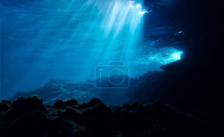 Artistic underwater photography of rays of sunlight over a reef