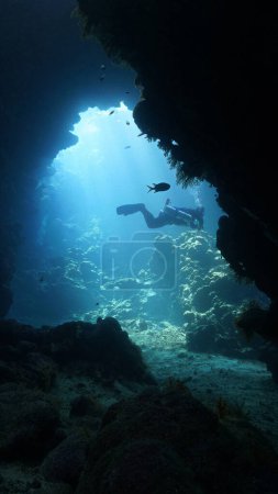 Foto de Foto submarina de rayos de sol dentro de una cueva y con un buceador - Imagen libre de derechos