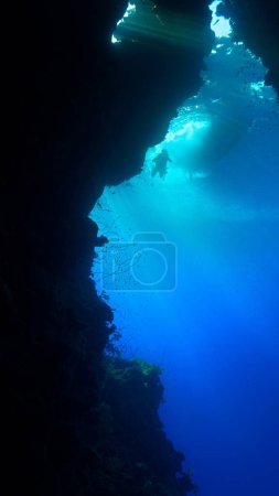 Photo for Underwater photo of rays of sunligt inside with a scuba diver at a cave entrance. - Royalty Free Image