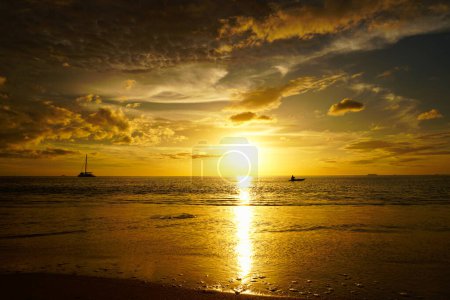 Téléchargez les photos : Destination pittoresque. Un kayak dans un magnifique coucher de soleil doré et des nuages au-dessus de l'océan. D'une île tropicale dans le sud de la Thaïlande. - en image libre de droit
