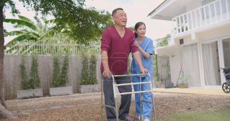 Asian Woman Nurse Supporting and Caring for Adult Male Patient Outdoors during the Recovery of Leg Injuries, Nurse Empowering Elderly Patients in their Recovery Journey