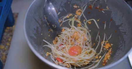 Téléchargez les photos : Fermer chef Cuisine délicieuse délicieuse salade de papaye verte épicée appelée SOM TAM au mortier pilon, la plus populaire en Thaïlande, cuisine de rue thaïlandaise - en image libre de droit