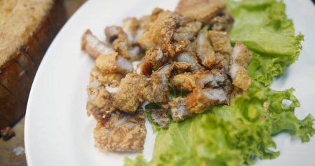 Nahaufnahme leckere traditionelle Thai beliebte berühmte Lebensmittel frittiert knusprige Streifen Schweinefleisch in weißem Teller