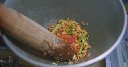 Hacer ensalada de papaya en un mortero Crear un plato saludable y picante con verduras frescas y hierbas exóticas, comida asiática auténtica cocina tailandesa