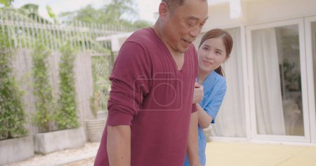 Enfermera asiática que apoya y cuida a un paciente varón adulto al aire libre durante la recuperación de lesiones en las piernas, enfermera que empodera a los pacientes ancianos en su viaje de recuperación