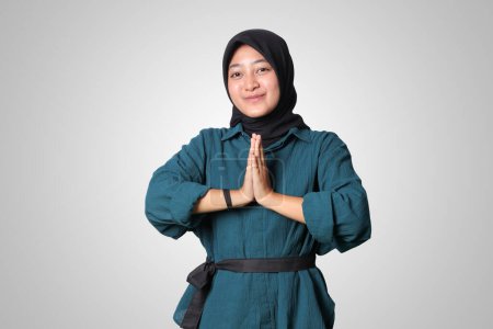 Téléchargez les photos : Portrait de femme asiatique joyeuse hijab en chemise décontractée, montrant des excuses et geste de bienvenue. Concept publicitaire. Image isolée sur fond blanc - en image libre de droit