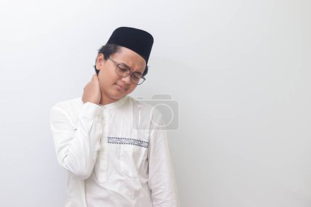 Téléchargez les photos : Portrait de jeune homme musulman asiatique ressentant de la douleur au cou. Image isolée sur fond blanc - en image libre de droit