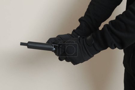 Photo for Close up of male hand reloading his pistol after shooting. Isolated image on gray background - Royalty Free Image