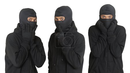 Téléchargez les photos : Un mystérieux voleur portant un sweat à capuche noir et un masque a été attrapé en se faufilant. Criminel choqué et effrayé. Image isolée sur fond gris - en image libre de droit