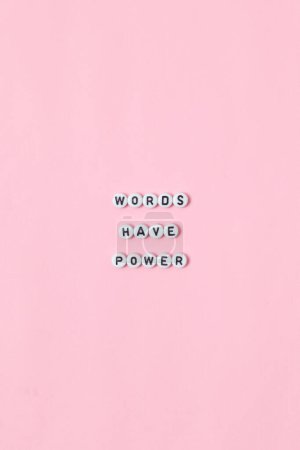 Téléchargez les photos : Vue du dessus de "mots ont le pouvoir" citations faites de perles sur fond rose. concept de motivation et de succès - en image libre de droit