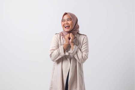 Téléchargez les photos : Portrait de jeune femme asiatique hijab réussie en costume décontracté semble heureux et souriant tout en pliant les bras devant sa poitrine. Image isolée sur fond blanc - en image libre de droit